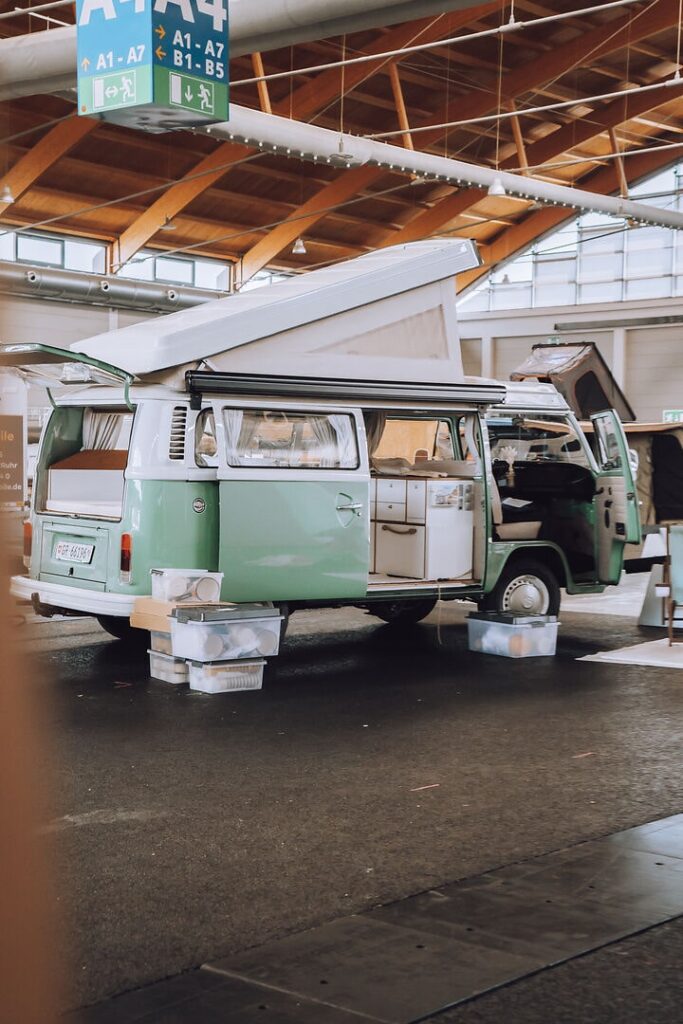 Schöner VW Bus in Türkis steht in der Messehalle