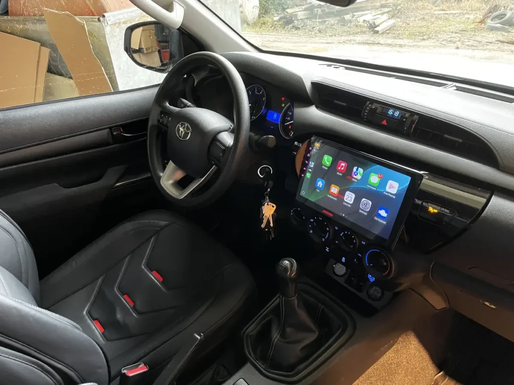 Modernes Interieur eines 4x4 Pick-ups mit Infotainment-System, Ledersitzen und manuellem Schaltgetriebe.