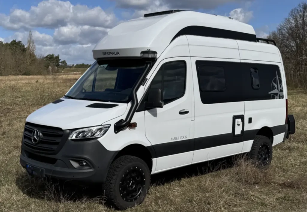 Weißer Offroad-Campervan mit Hochdach, Schnorchel und Allradantrieb im Gelände.