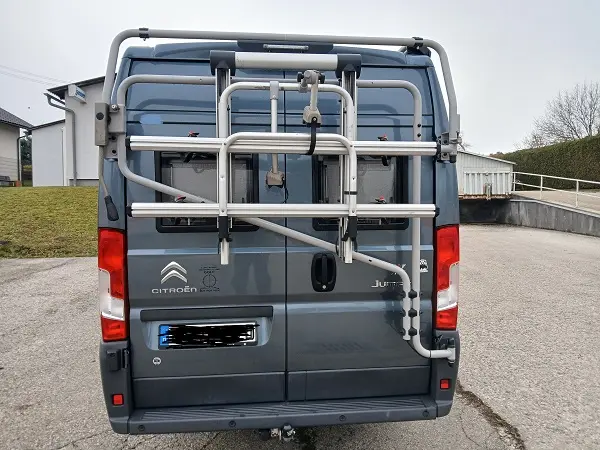 Grauer Citroën Jumper Campervan von hinten mit montiertem Heck-Fahrradträger.