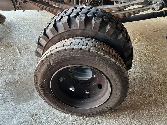 Ein grobstolliger Offroad-Reifen und ein Straßenreifen an einem LKW-Fahrgestell.